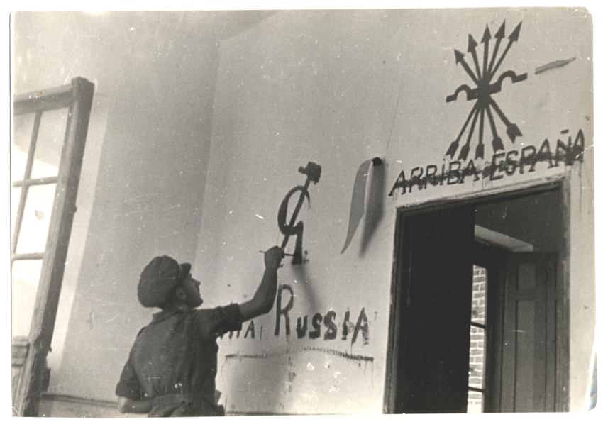 luglio 1937, Brunete: repubblicano cancella il motto fascista “Arriba España” e disegna la falce e il martello - foto di Gerda Taro